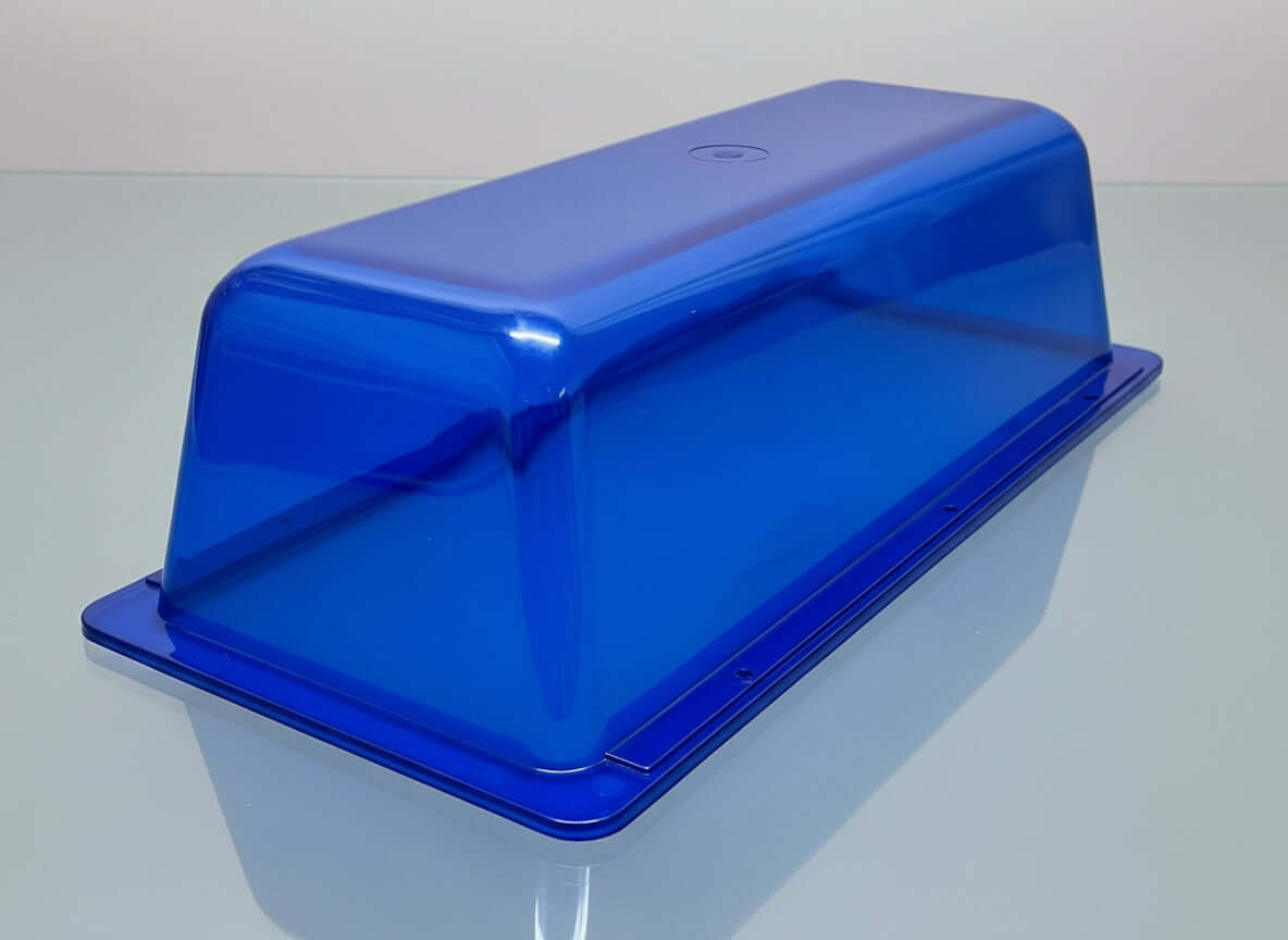 A blue replacement dome with a gasket for a vehicle light, placed on a wooden surface.