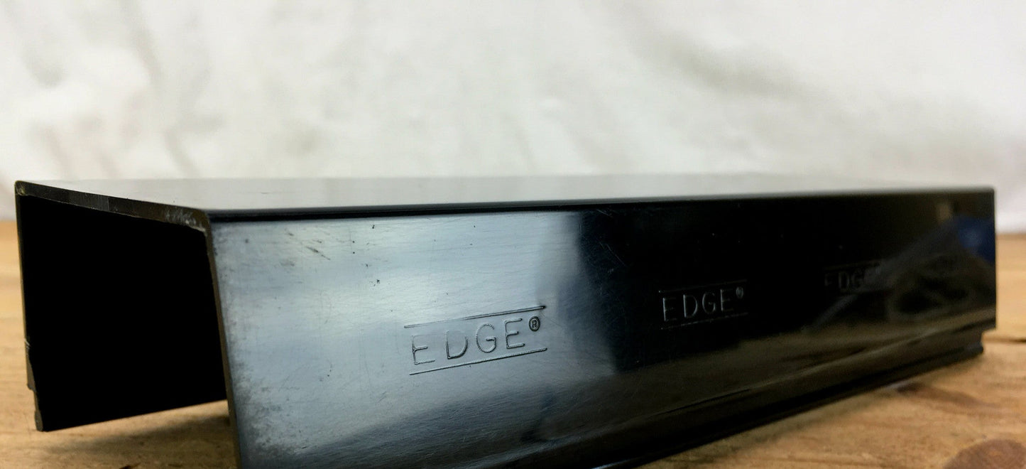 Whelen Edge Freedom Lightbar with a blackout lens section, showing some minor scuffs and scratches, placed on a wooden surface.