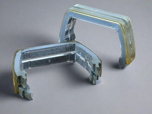 A pair of clear lens dividers or spacers for a Whelen lightbar, showing slight scuff marks and yellowing.